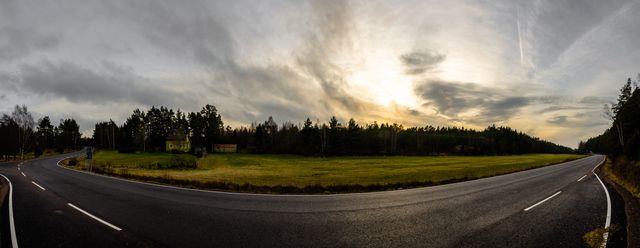 Panoramic view of empty rural highway at sunset with forest in background - Download Free Stock Photos Pikwizard.com
