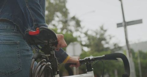 Urban Cyclist Gripping Bicycle by Handlebars and Seat