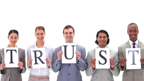 Business Team Holding Trust Signs in Professional Setting
