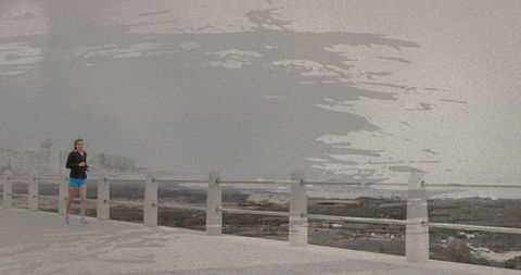 Female runner pausing and checking smartphone on coastal walkway by railing, fitness lifestyle