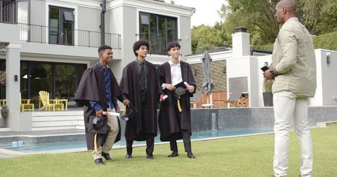 Proud Father Photographs Diverse Graduates Celebration Outdoors