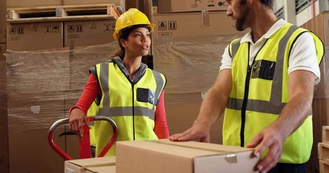 Warehouse workers discussing load management in distribution center