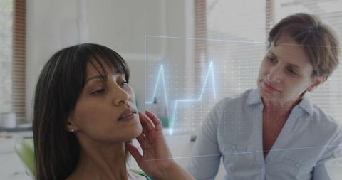 Clinician examining patient neck with holographic ecg waveform displaying vital signs