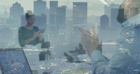 Boardroom collaboration with city skyline overlay, professionals using devices and laptop