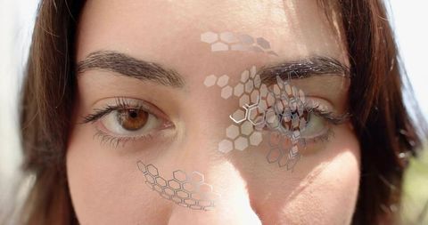 Gazing brown-eyed woman wearing hexagonal pattern overlay, sunlit close-up portrait