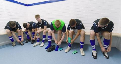Teen Athletes in Locker Room Preparing for Soccer Game