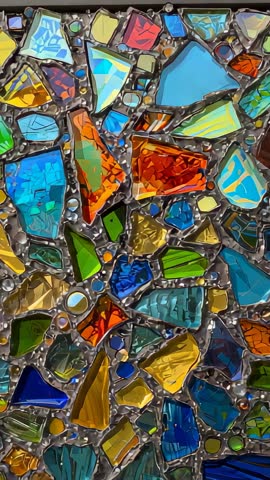 Vertical panning revealing colorful backlit stained glass mosaic with solder details