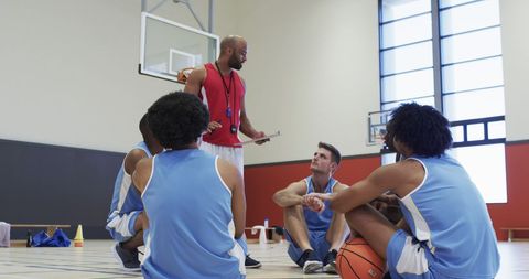 Basketball Coach Advising Male Team Indoors