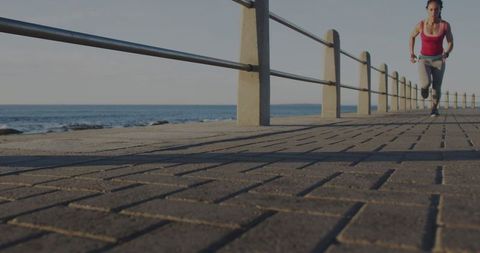 Woman Running Along Ocean Promenade
