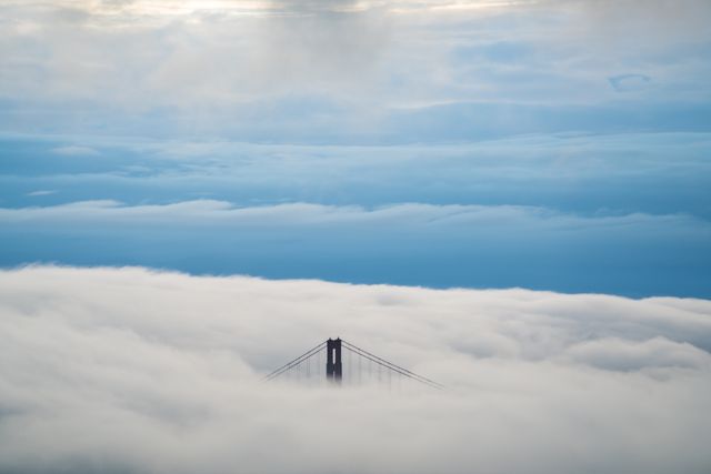 Golden Gate Bridge Towers Emerging from Fog Under Blue Sky - Download Free Stock Photos Pikwizard.com
