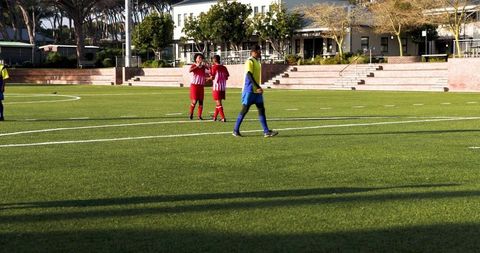 Soccer Players Competing on Sunny Field during Game