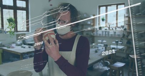 Masked artisan evaluating handmade pottery with data overlay in studio