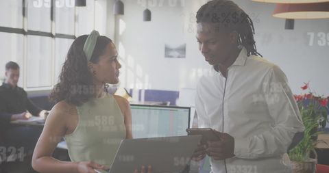 Diverse Colleagues Engaged in Data Discussion at Modern Office