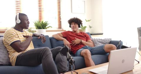 Diverse male friends on sofa recording casual podcast session