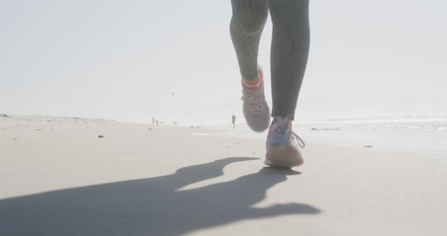 Person Jogging on Sandy Ocean Beach in Morning Light - Download Free Stock Images Pikwizard.com