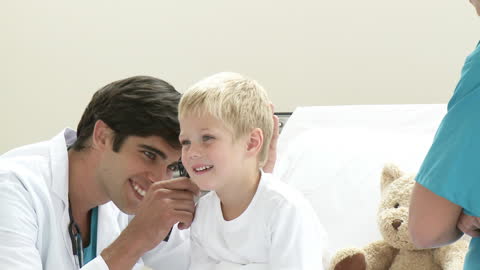 Pediatric Doctor Using Otoscope on Smiling Child