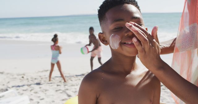 Smiling Boy Applying Sunscreen at Sunny Beach - Download Free Stock Images Pikwizard.com