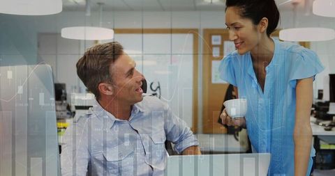 Team Collaborating Over Data Analytics, Smiling Colleagues Sharing Insights in Open Office