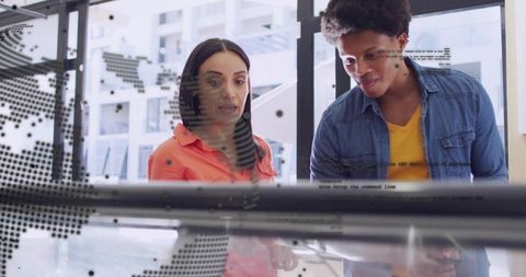 Team collaborating on interactive touch table with digital map overlay