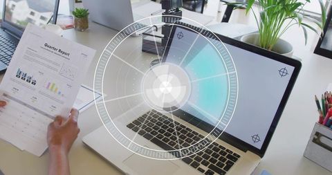 Woman Holding Quarterly Report Reviewing Analytics with AR HUD Overlay over Laptop