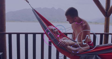 Relaxing couple lounging in hammock on lakeside balcony with neon social overlays