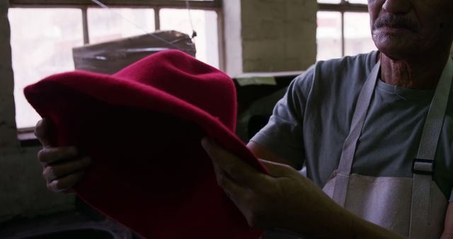 Senior Artisan Holding Red Felt Hat in Workshop - Download Free Stock Images Pikwizard.com