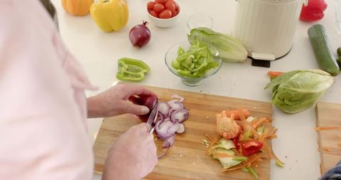 Senior Couple Preparing Fresh Vegetables in Rustic Kitchen