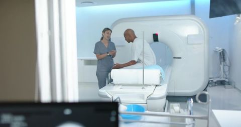 Patient consulting with mri technologist in modern radiology suite preparing for scan