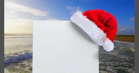 Santa hat on blank card by ocean wave background