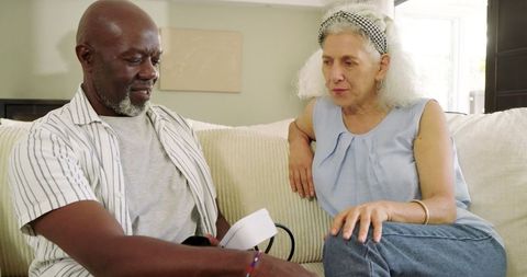 Senior Couple Monitoring Blood Pressure at Home on Sofa