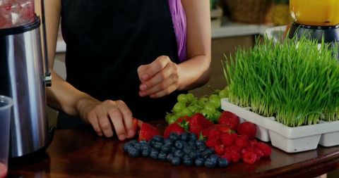 Woman Slices Fresh Berries with Kitchen Essentials for Healthy Living