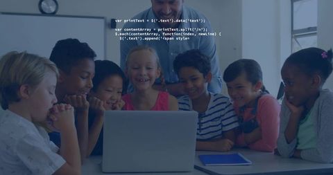 Teacher guiding diverse elementary students around laptop for collaborative coding lesson