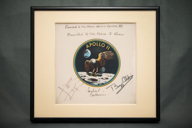 Plaque commemorating Apollo 11 mission, signed by the crew with eagle and Earth design. Presented to Administrator James C. Fletcher for future Mars I crew. Ideal for use in articles, blogs, and exhibits about space history, NASA missions, and memorabilia collectors.