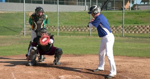 Male Baseball Players and Umpire at Home Plate during Game
