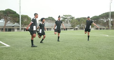 Team of Soccer Players Coordinating Stretching Routine on Field