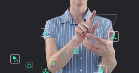 Mature woman tapping transparent tablet with holographic green energy and finance icons