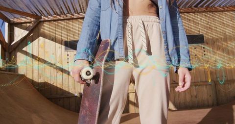 Skateboarder holding board on sunlit backyard ramp with rustic wooden panels and digital waveform ov
