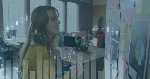 Woman analyzing data on whiteboard in office with overlay charts