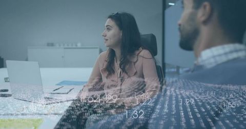 Professional team collaborating with woman gesturing at laptop during data-driven meeting