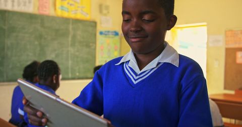African American Schoolboy Engaged with Tablet in Classroom Setting