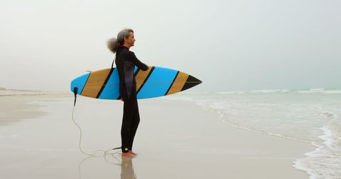 Senior African American Woman Surfer on Beach with Surfboard at Sea - Download Free Stock Images Pikwizard.com