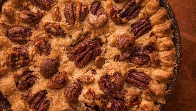 Rustic pecan pie with glossy caramel filling and flaky golden crust close-up