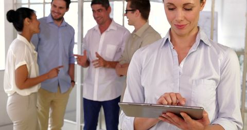 Focused Businesswoman Using Tablet with Team in Background - Download Free Stock Images Pikwizard.com