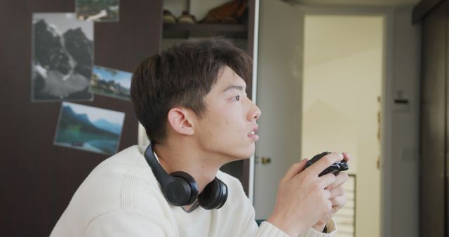 Asian boy playing image games sitting on the couch at home. teenager lifestyle and living concept
