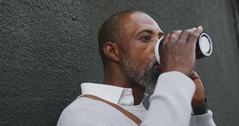 Man Enjoying Coffee While Talking on Smartphone