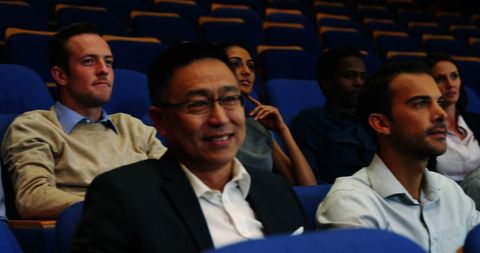 Diverse audience engages in professional seminar at theater