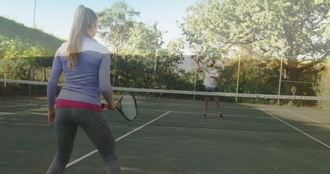 Competitive Female Tennis Match on Outdoor Hard Court