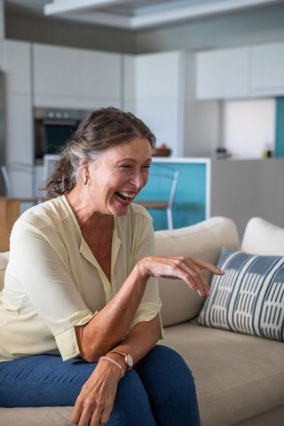 Joyful Senior Woman Relaxing in Modern Minimalist Home Setting
