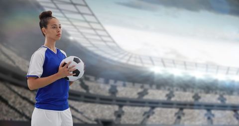 Female Soccer Player Holding Ball in Stadium