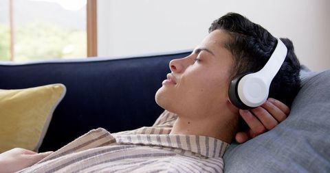 Relaxed Man Enjoying Music Through Headphones on Sofa